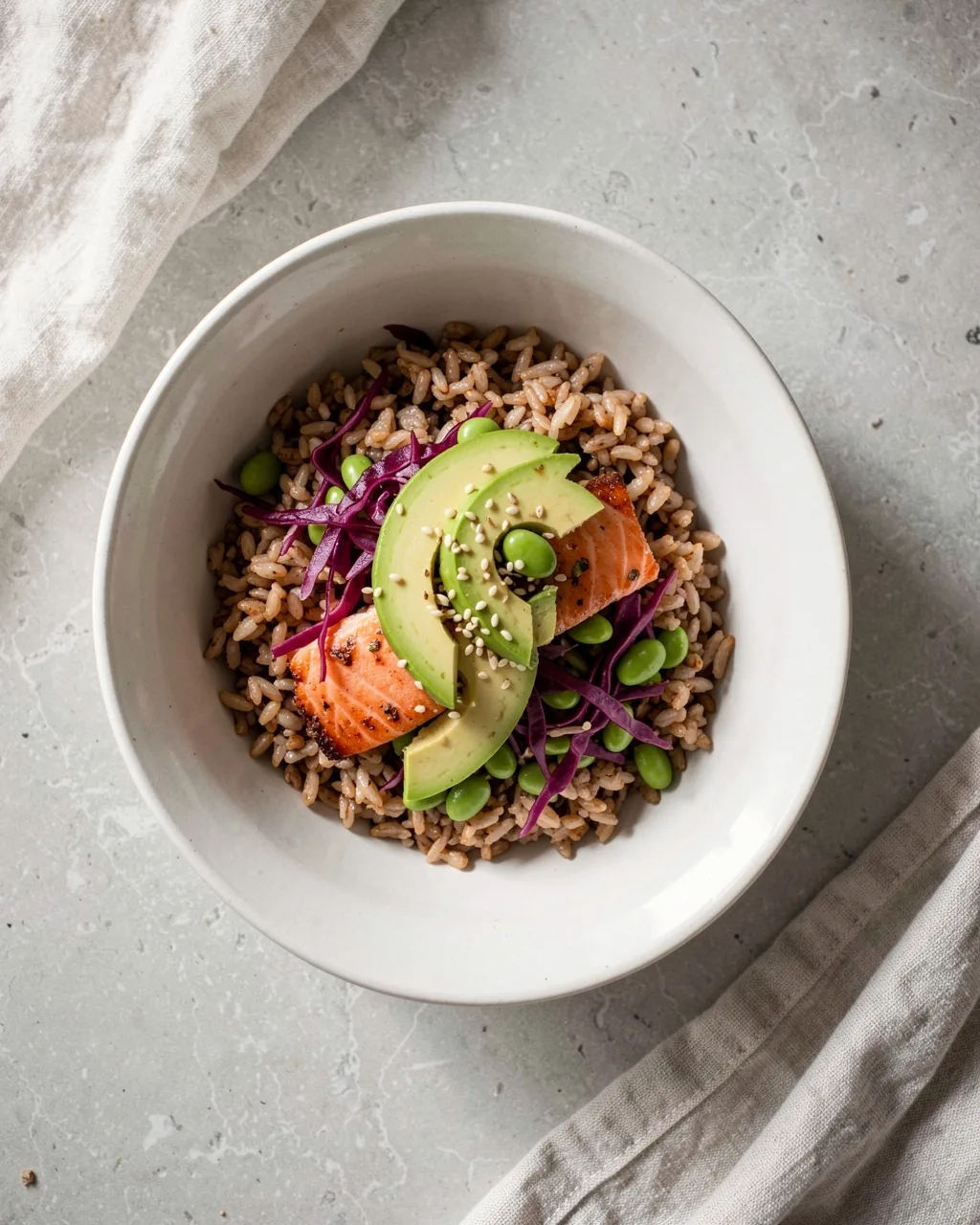 A bowl of brown rice with roast salmon, avocado and red cabbage