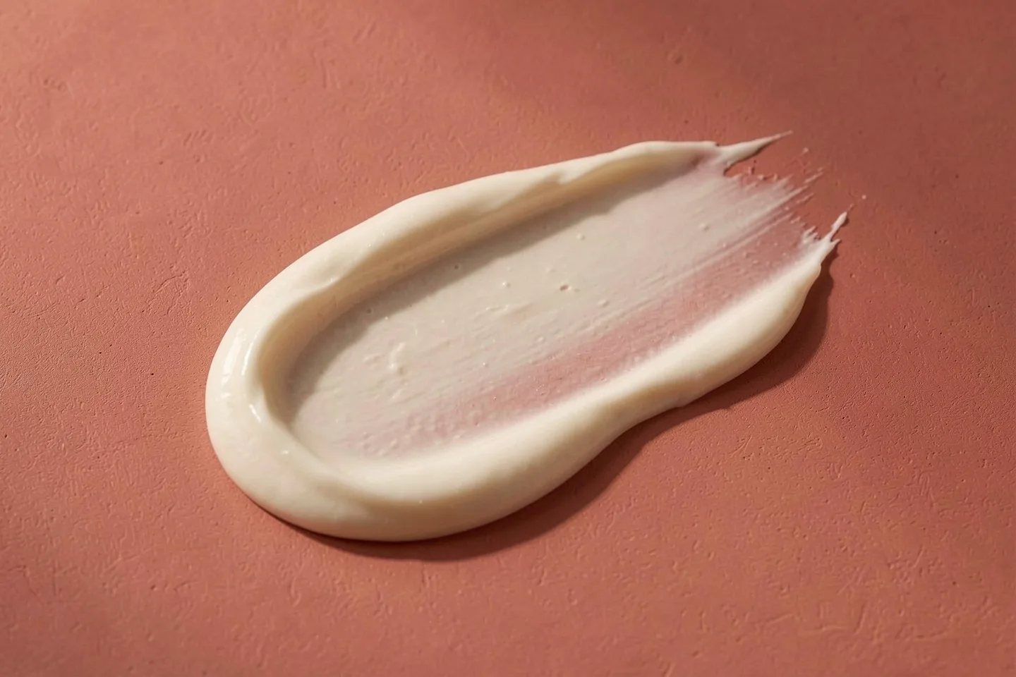 A thick swirl of cream on a terracotta surface
