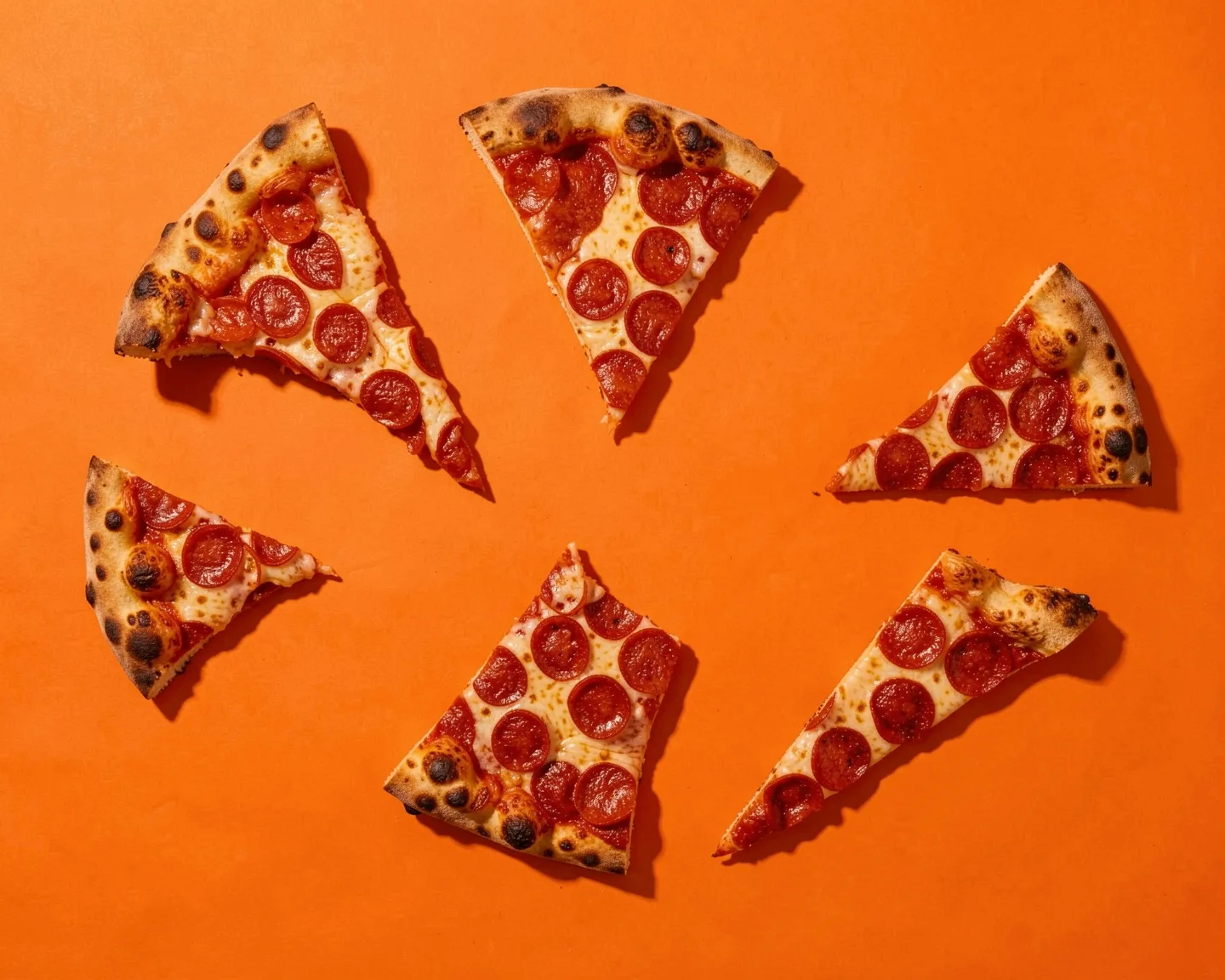 Pepperoni slices laid out on orange paper