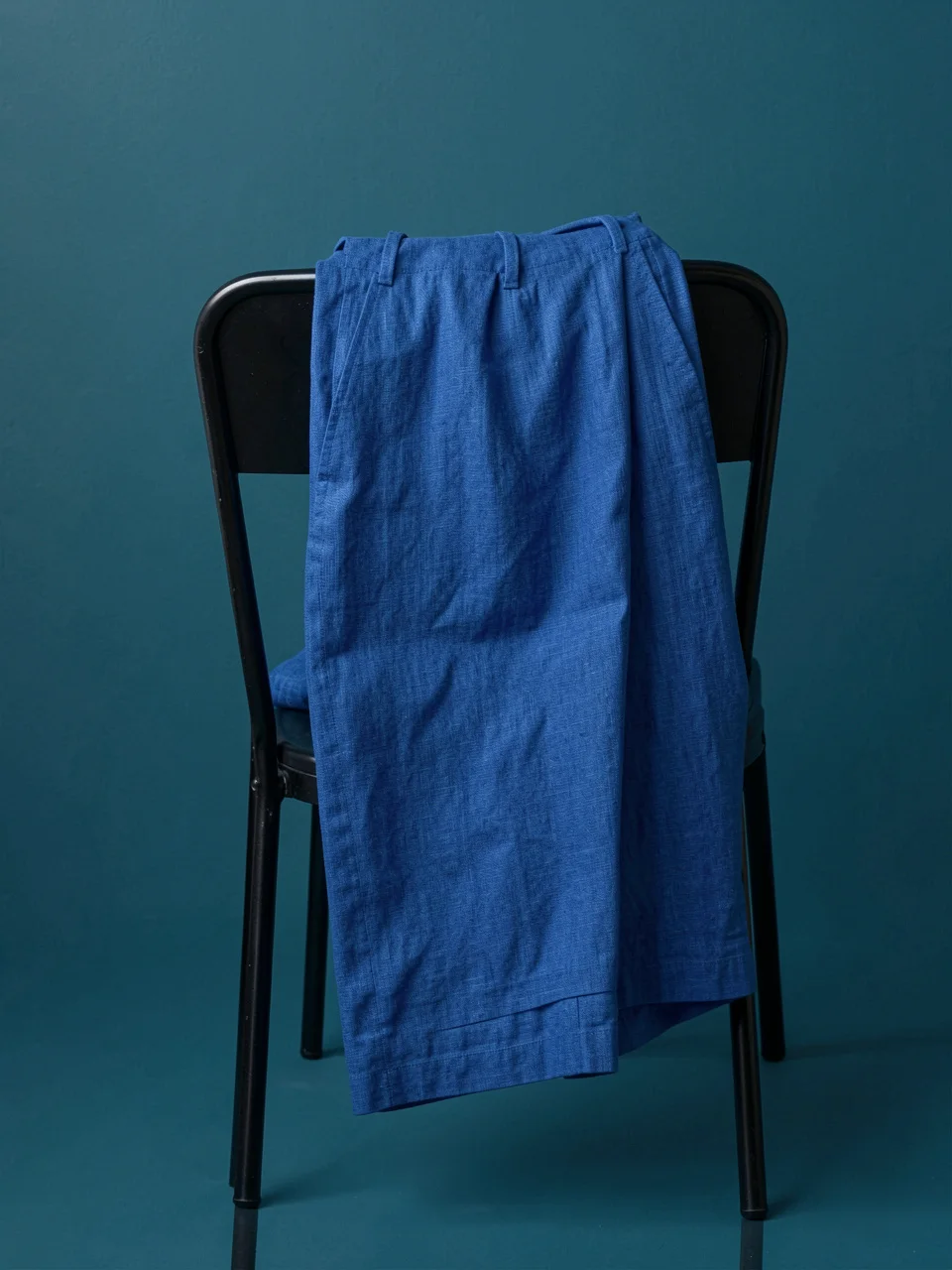 Cobalt linen trousers over the back of a chair