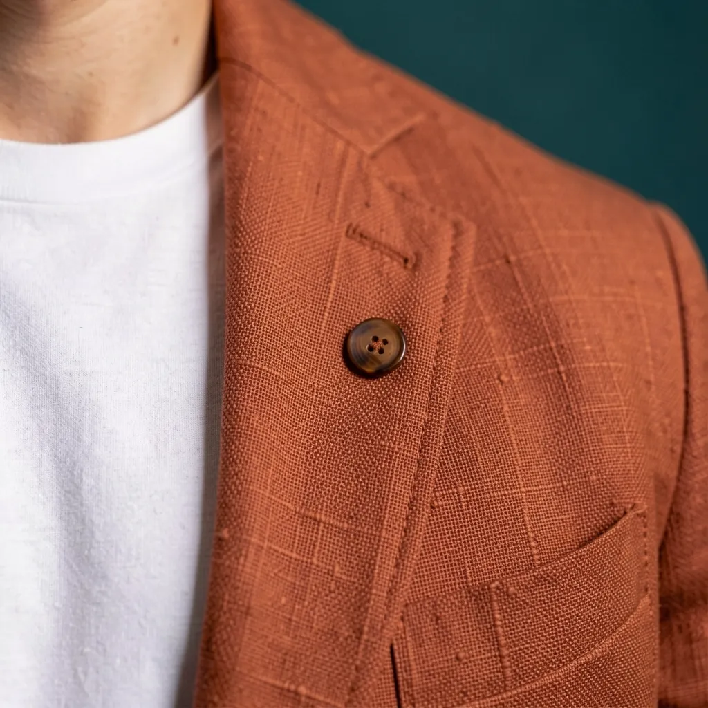 The rust linen up close, with a horn button