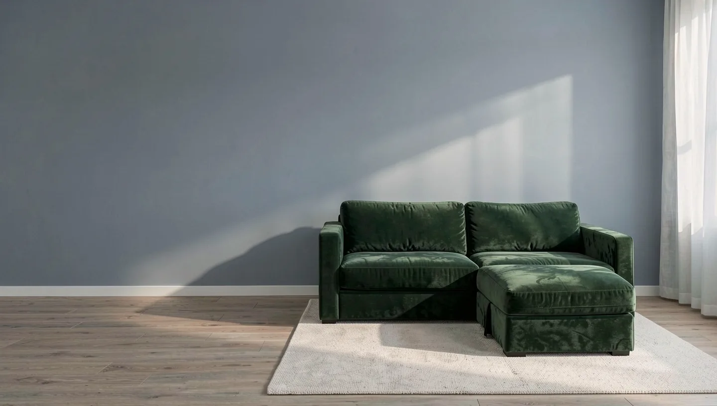 The velvet modular sofa in moss green on a wool rug against a blue-grey wall