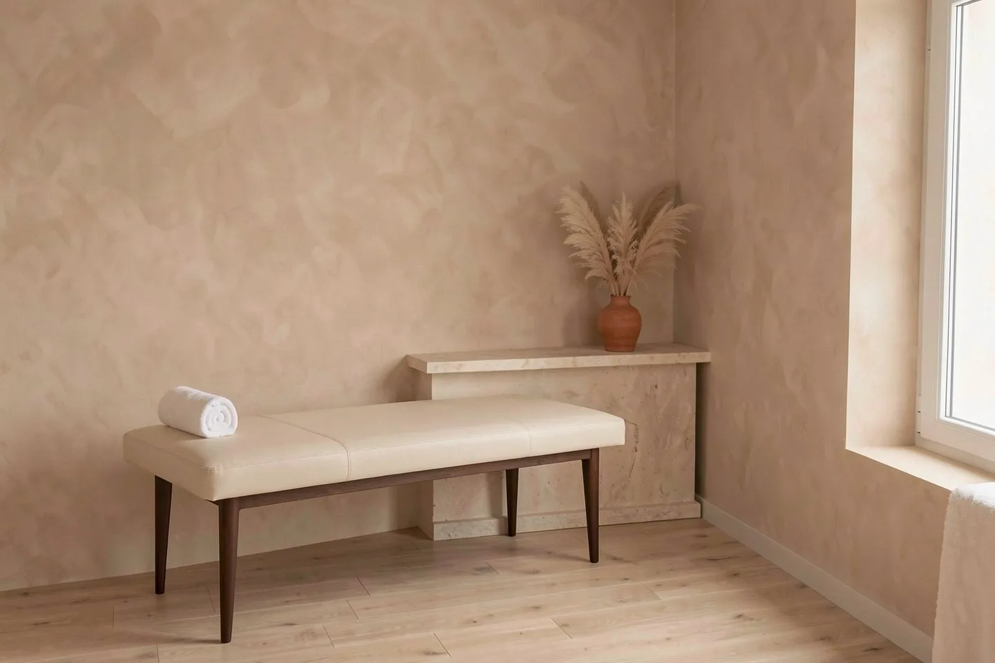 A treatment room with a cream bed and dried grasses