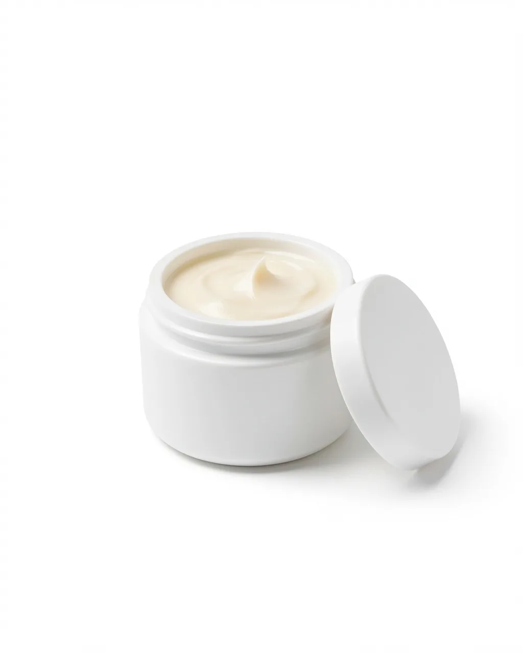 An open jar of night balm with its lid beside it