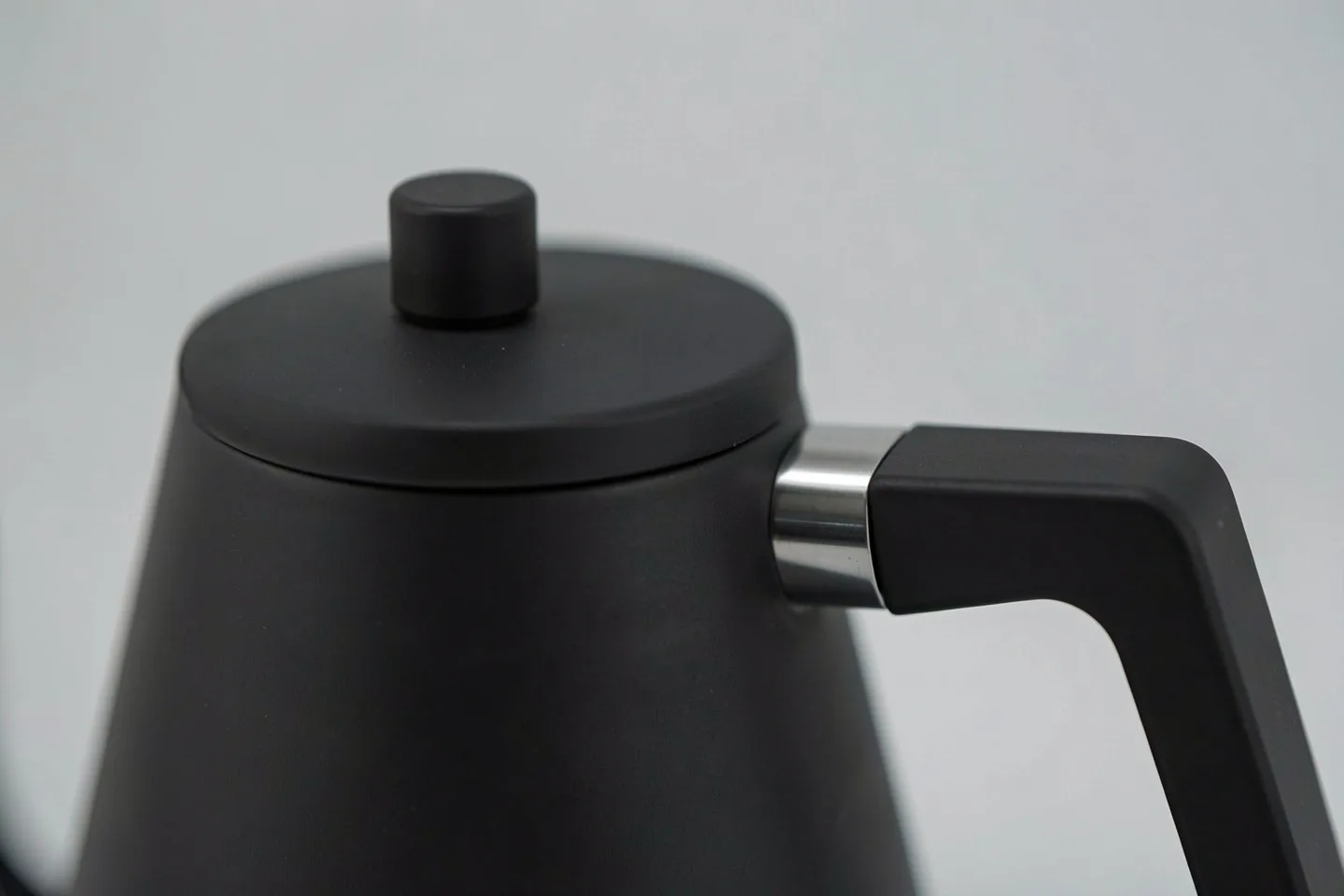 The lid, its knob and the steel collar of the handle, up close
