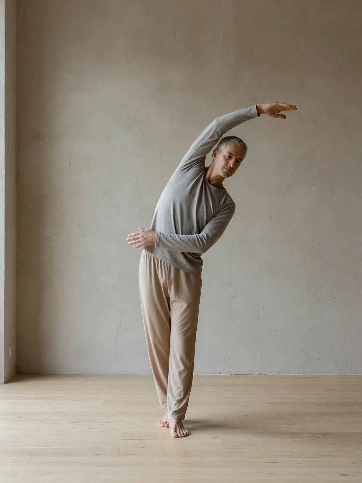 A man doing a standing side stretch, one arm overhead