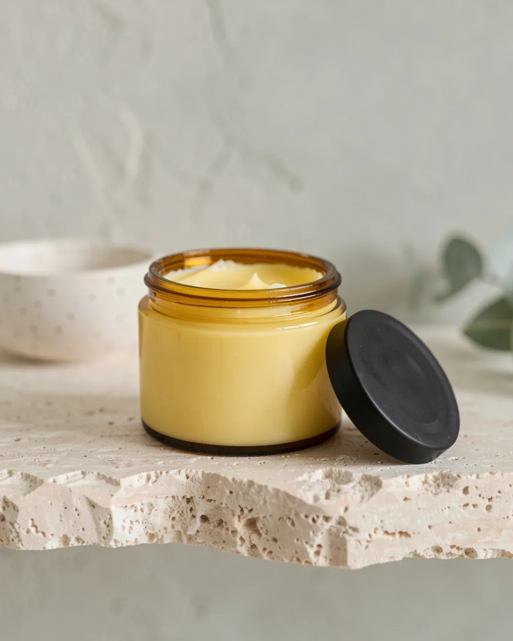 The cleansing balm in an open amber jar